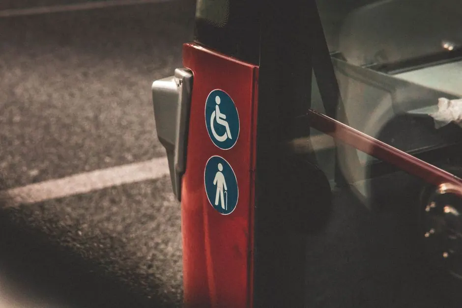 Close-up view of accessibility and elderly symbols on a red city bus.