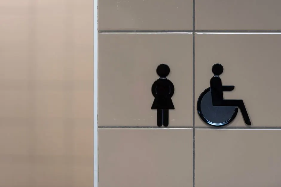 Signage showing symbols for an inclusive restroom with wheelchair accessibility.